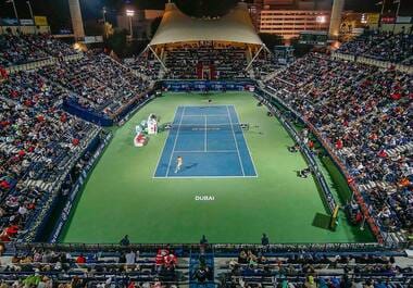 The Dubai Duty Free Tennis Stadium at night with full stands.